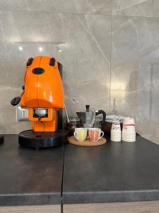 Casa Foria Holiday Home Naples في نابولي: آلة صنع القهوة البرتقال على رأس العداد