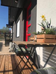 una mesa de picnic fuera de una casa con una flor. en Pogánykő Vendégház 2 en Pákozd