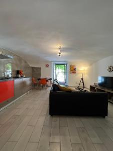 Casa Foria Holiday Home Naples في نابولي: غرفة معيشة مع أريكة سوداء ومطبخ