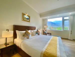 a bedroom with a large bed with a large window at Green View by Green Tree Hotels in Rishīkesh