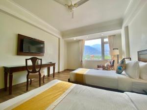 Green View by Green Tree Hotels في ريشيكيش: غرفة فندقية بسريرين ومكتب وتلفزيون