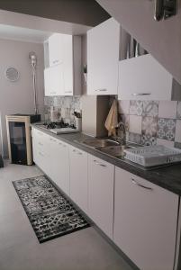 a kitchen with white cabinets and a sink at SoleLuna in Santa Elisabetta