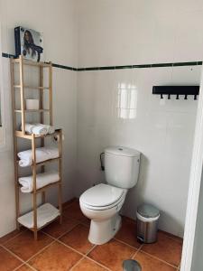 a bathroom with a toilet and a shelf with towels at Convento Hermana Esther in Alosno +29 photos