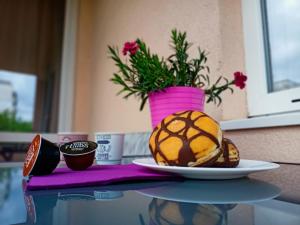 einen Tisch mit einem Teller Essen und eine Vase mit Blumen in der Unterkunft Стоянови in Ruse