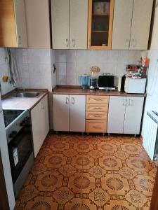 Una cocina con gabinetes blancos y piso de baldosas. en Centar Apartments, en Skopje 6 fotos más
