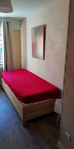 Cama en habitación con colcha roja en colmar, en Horbourg