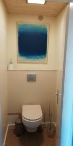 a bathroom with a toilet and a painting on the wall at colmar in Horbourg