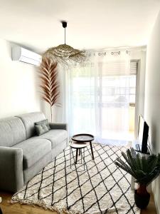 a living room with a couch and a table at L'Escapade Bohème in La Grande-Motte