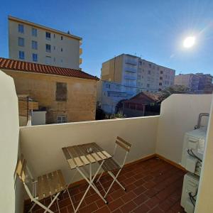a balcony with a table and chairs on a roof at Ezz'Hotel Canet in Canet-en-Roussillon