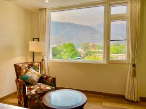 Green View by Green Tree Hotels في ريشيكيش: غرفة بها نافذة وكرسي وطاولة