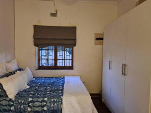 约翰内斯堡Quaint, quiet retro charm的一间卧室，里面有一张床和一扇窗户。