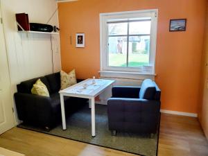 a living room with two chairs and a table and a window at Ferienwohnung 2 bei Familie Saupe in Schaprode