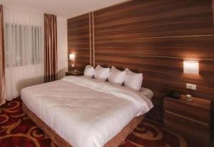a bedroom with a large bed with a wooden wall at Park Plaza Hotel in Amman