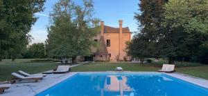 a swimming pool with lounge chairs in front of a house at Villa Irene in Casale sul Sile