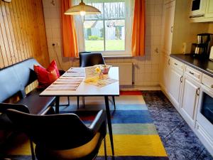 a kitchen with a table and chairs and a window at Ferienwohnung 1 bei Familie Saupe in Schaprode