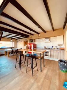 a large kitchen with wooden ceilings and wooden tables at Casas De Montaña Las Leñas Los Molles in Los Molles