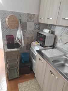 uma pequena cozinha com um lavatório e um micro-ondas em La lammia di Pisticci em Pisticci