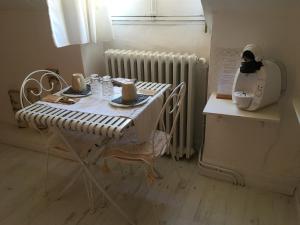 stół z krzesłami i ekspres do kawy w kuchni w obiekcie Les remparts w mieście Luz-Saint-Sauveur