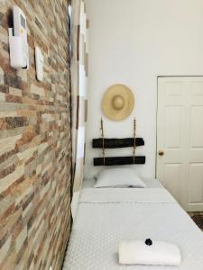 Cette petite chambre comprend un lit et un mur en briques. dans l'établissement Casa Mama Fanti, à Esquipulas