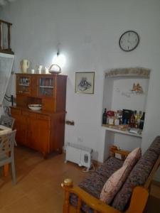 a living room with a couch and a clock on the wall at La lammia di Pisticci in Pisticci
