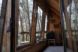 widok na ganek domku z bali z oknami w obiekcie Domek na Drzewie! w mieście Rudka Gołębska