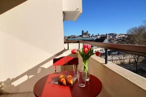 - une table avec un vase de fleurs sur le balcon dans l'établissement ÉPIPAPU Appartement 57 M2 - Parking privé - Loggia -, à Bourges