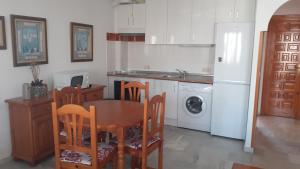 La cuisine est équipée d'une table, de chaises et d'un réfrigérateur blanc. dans l'établissement Urbanizacion Vera Costa, Vera, à Vera