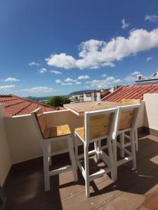 einen Tisch und zwei Stühle auf einem Dach in der Unterkunft Tree House in Setúbal