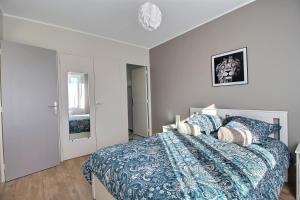 Schlafzimmer mit einem Bett mit blauer Decke in der Unterkunft ÉPIPAPU Appartement 57 M2 - Parking privé - Loggia - in Bourges