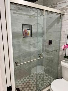 a glass shower door in a bathroom with a toilet at VillaBella in Fort Myers