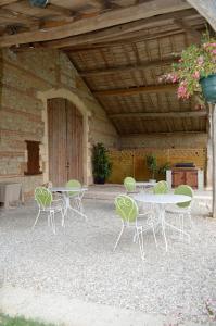 a group of tables and chairs under a building at La Cascade de Hauterive in Pinel-Hauterive