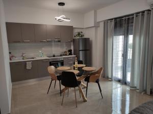 a kitchen and dining room with a table and chairs at Grey Swan - Modern & Stylish apartment with Private Parking in Volos