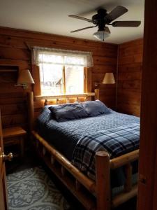 - une chambre avec un lit, un ventilateur de plafond et une fenêtre dans l'établissement Warrens Cabin, à Warrens