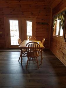 ein Esszimmer mit einem Tisch und Stühlen in einer Hütte in der Unterkunft Warrens Cabin in Warrens
