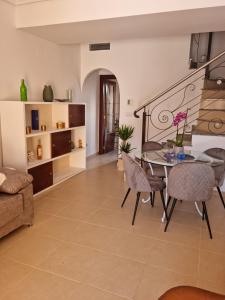 克薩達城的住宿－AGRADABLE ADOSADO CON PISCINA，客厅配有桌椅