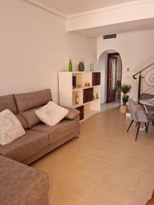 uma sala de estar com um sofá e uma mesa em AGRADABLE ADOSADO CON PISCINA em Ciudad Quesada