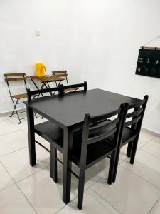 a black table and chairs in a room at TheREHAT Homestay Kijal Terengganu in Kijal