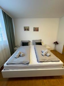 a large bed with two pillows on it in a bedroom at Apartment Green - Grey in Ljubljana