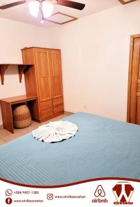 1 dormitorio con 1 cama y armario de madera en Sunset Waves, en Roatan