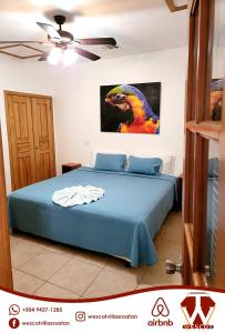 1 dormitorio con 1 cama con una pintura en la pared en Sunset Waves, en Roatan