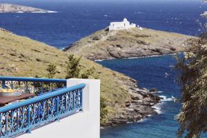 a blue and white balcony with a view of the ocean at Tramontana Suites in Áyios Stéfanos