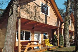 Cabaña de madera con mesa de picnic y sillas amarillas en Holiday resort in Pobierowo for 6 persons, en Pobierowo