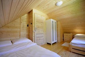 ポビエロボにあるHoliday resort in Pobierowo for 6 personsの木造キャビン内のベッドルーム1室(ベッド2台付)