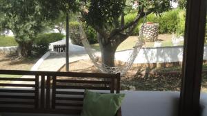 una hamaca en un patio con un árbol en Casa De Vacacion, en Gerakini