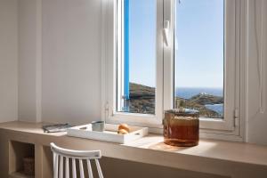 a window with a drink on a counter in front of it at Tramontana Suites in Áyios Stéfanos