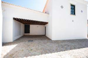 an empty courtyard of a white building at Casas São João by Ana Ferro Rentals in Arcozelo +166 photos