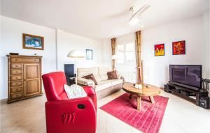 a living room with a red chair and a couch at Stunning Apartment In Vinars With Wifi And 2 Bedrooms in Vinarós