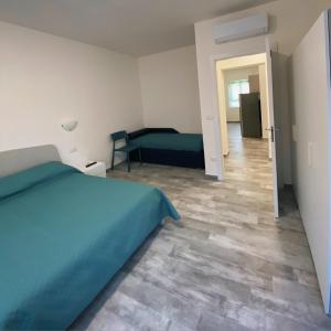 sypialnia z niebieskim łóżkiem i korytarzem w obiekcie PM 29 Guest House w mieście Alghero