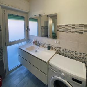 a bathroom with a sink and a washing machine at PM 29 Guest House in Alghero