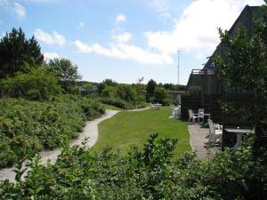 a garden with chairs and tables and a building at Appartement Baken in Hollum